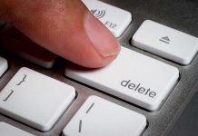 Finger pressing a delete key on keyboard