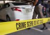 Crime scene tape near a white car