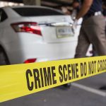 Crime scene tape near a white car