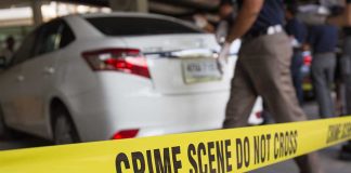 Crime scene tape near a white car