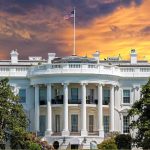 White House with sunset sky background and flag