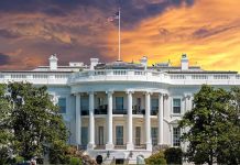 White House with sunset sky background and flag
