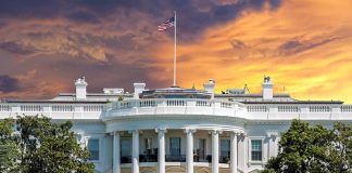 White House with sunset sky background and flag