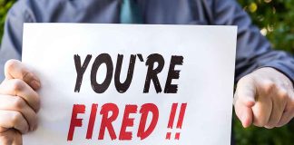 Person holding you're fired sign