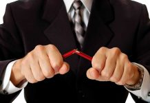Person breaking red pencil with both hands