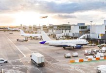 Airport with airplanes runway and terminal at sunset