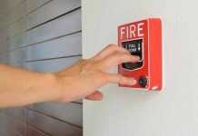 Hand reaching to pull fire alarm lever
