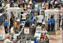 Airport security checkpoint with passengers and staff busy