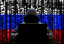 Hacker in hoodie with Russian flag background and code