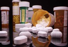 Various prescription pill bottles with scattered white tablets