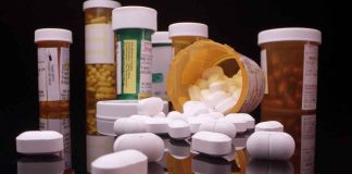 Various prescription pill bottles with scattered white tablets