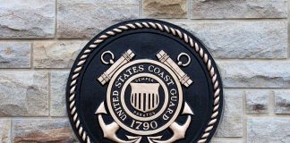 United States Coast Guard emblem on stone wall.