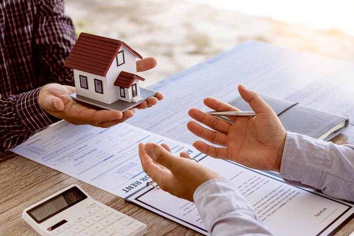 2050679492 featured image Hands exchanging miniature house over contracts