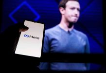 Phone displaying Meta logo in front of presentation