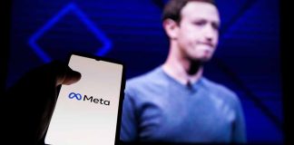 Phone displaying Meta logo in front of presentation