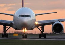 Airplane on runway during sunset lights on