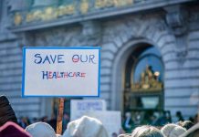 Sign reading Save Our Healthcare at protest