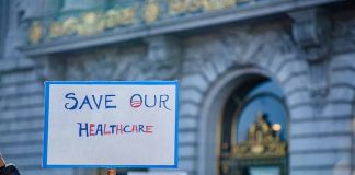 Sign reading Save Our Healthcare at protest