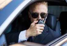 Man in suit using walkie talkie in car