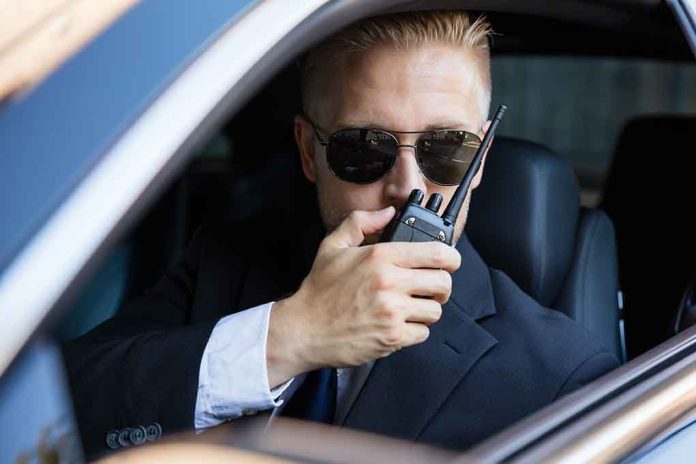 561916870 featured image Man in suit using walkie talkie in car