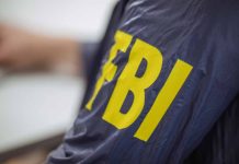 Person wearing jacket with FBI in yellow letters