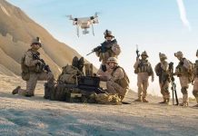 Soldiers operating drone in desert landscape with equipment