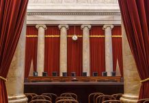 Empty courtroom with columns red curtains and chairs