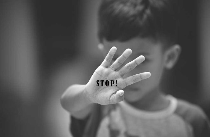 754809316 featured image Child holding up hand with STOP written on palm