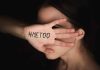Hand with #MeToo covering face