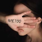 Hand with #MeToo covering face