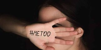 Hand with #MeToo covering face