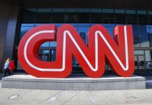 Large red CNN sign outside building entrance