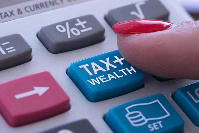 Finger pressing calculator tax and wealth button