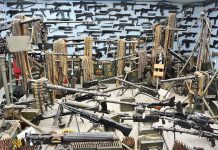 Room filled with various firearms and ammunition belts