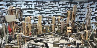 Room filled with various firearms and ammunition belts