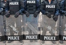 Police officers in riot gear holding shields