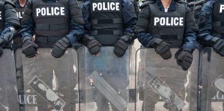Police officers in riot gear holding shields
