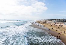 Crowded beach with waves and people enjoying sun