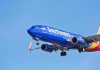 Southwest Airlines plane flying in blue sky.