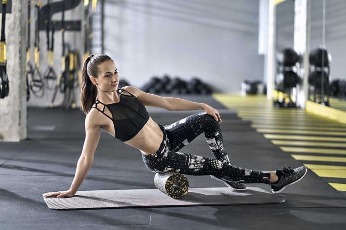 1104978155 Woman using foam roller in gym setting
