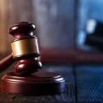 Gavel on wooden table in dimly lit room