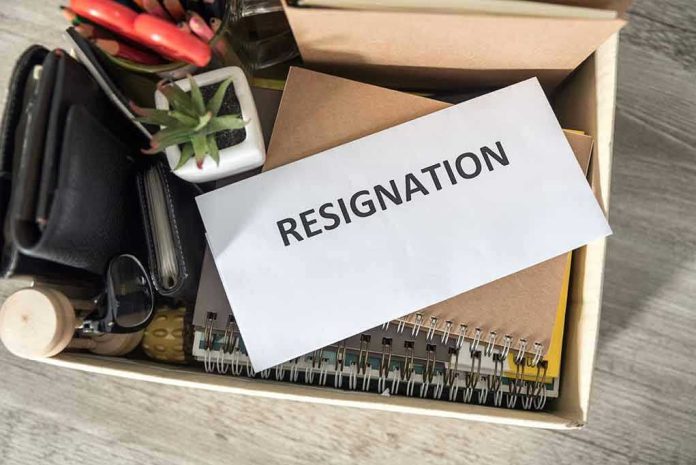1487893499 Envelope labeled resignation in a box of office items