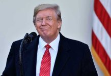 Man in suit and tie speaking at podium