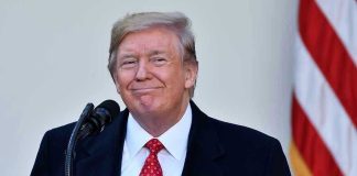 Man in suit and tie speaking at podium