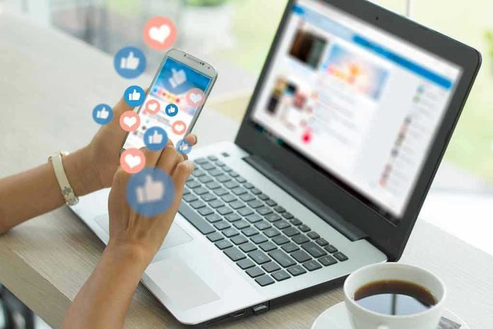1573945981 Person using smartphone and laptop with social media icons