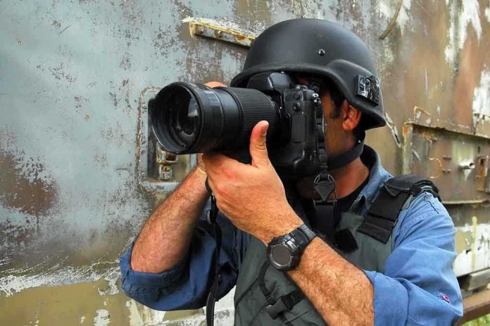 Person in helmet taking photos with a large camera