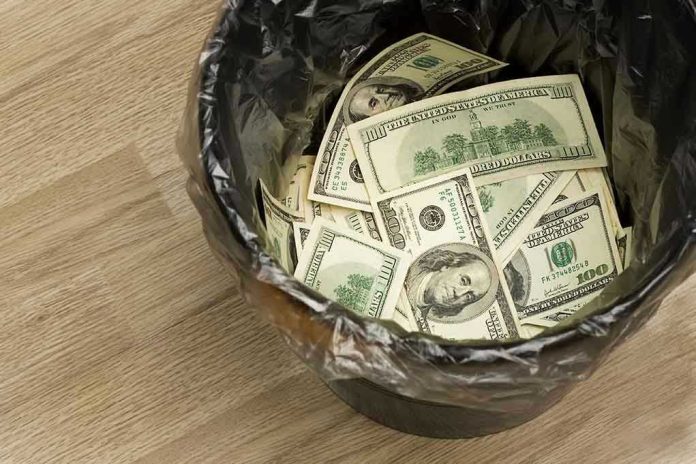 24911320 Trash bin filled with one hundred dollar bills