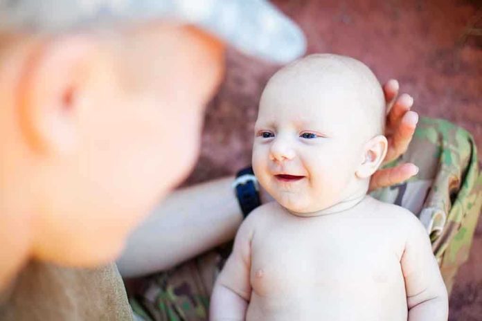 shutterstock_188297519.jpg A smiling baby interacting with a parent in a military uniform