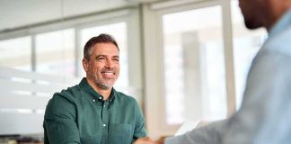 Two professionals shaking hands in an office setting