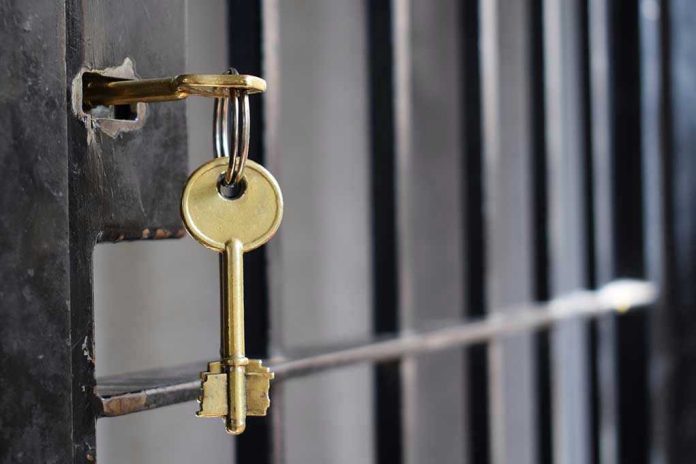 1134195950 Key in lock of prison cell door.